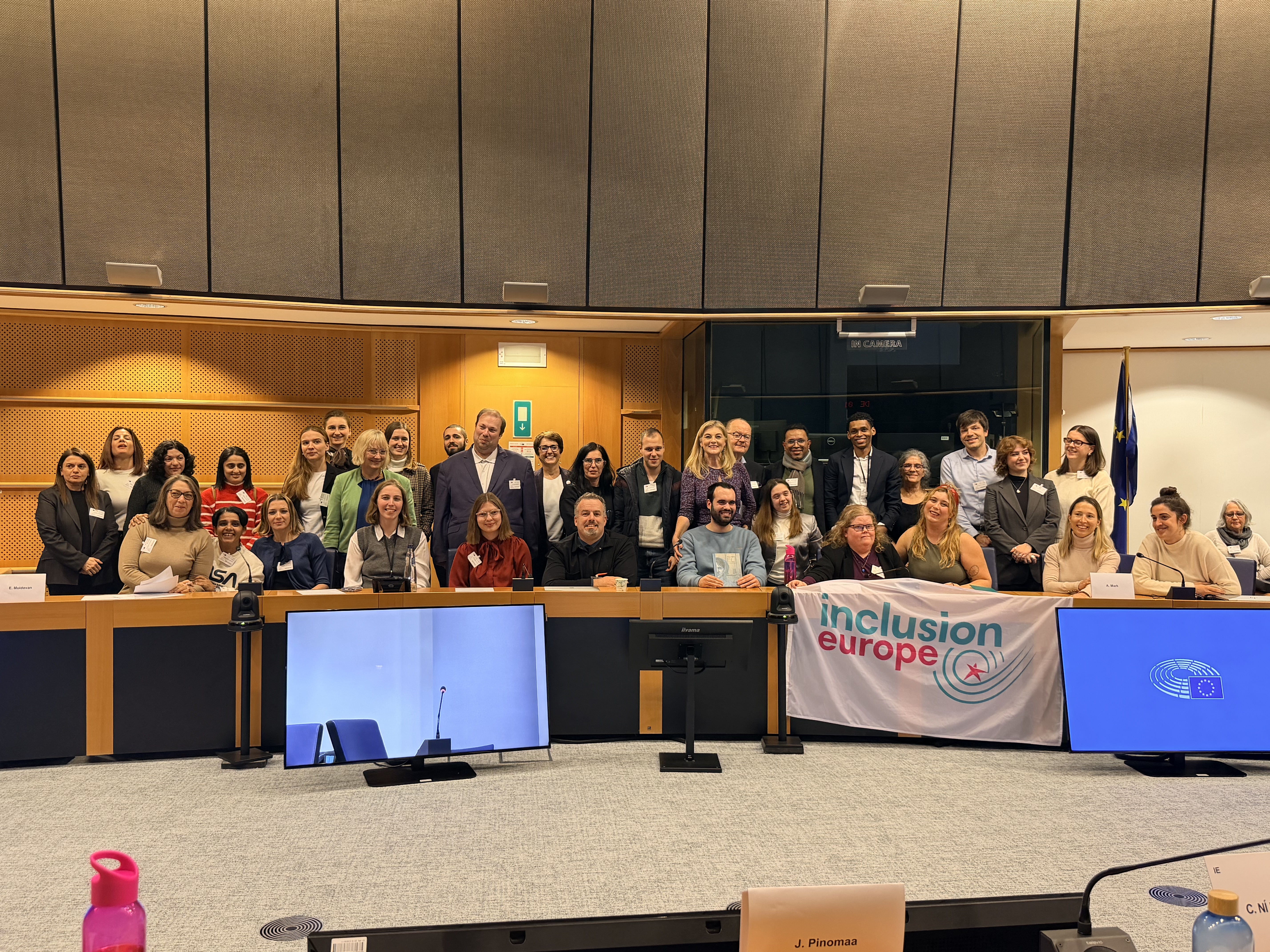 Event participants taking a group photo with Inclusion Europe logo