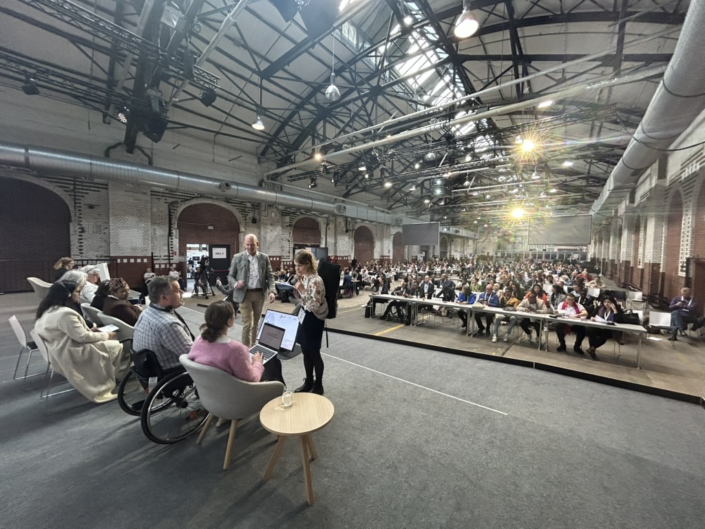Self-advocates on stage, with over 200 participants in the room
