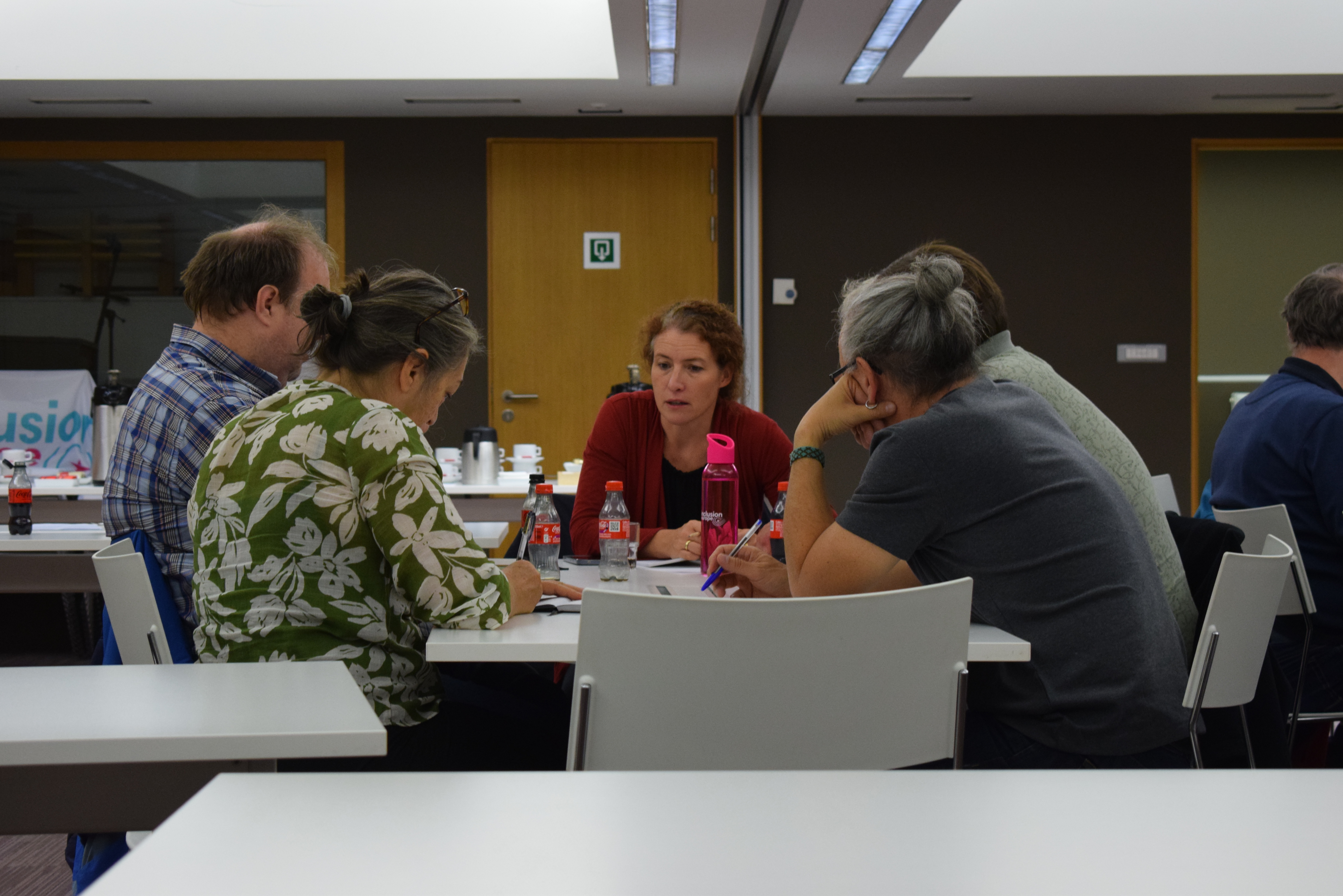 Small group participants sitting around a table and discussing